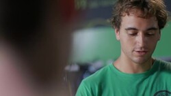 Retail shop employee consults tablet computer and chats with customer at sales counter Stock Footage