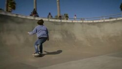 skater drops into bowl and skates around camera venice California skatepark Stock Footage