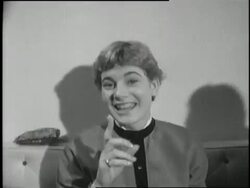 A woman's hand powders a large poodle's nose. News Clip