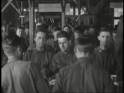 Soldiers sit down at tables in a mess hall for a meal. News Clip
