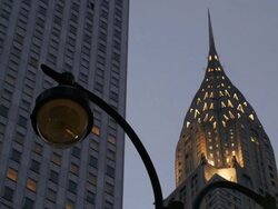 Chrysler Building stacked between apartment buildings at dusk. An old street lamp is featured. Stock Footage