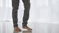 Man walking on tiled white floor Stock Footage