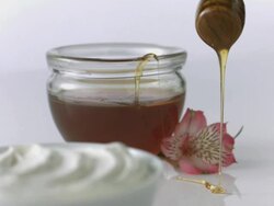 Honey dipper drizzles honey over yogurt  Stock Footage