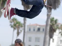 MS SLO MO Shot of two guys completing aerial trick and landing / Venice, California, United States Stock Footage