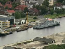 AERIAL Military ship in naval base, Wilhelmshaven, Lower Saxony, Germany Stock Footage