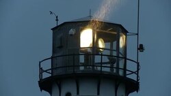 Rain falls as lighthouse beams rotate. Stock Footage