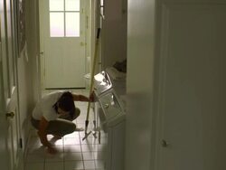 WS, PAN, Woman cleaning tile floor in laundry room, Hollywood, California, USA Stock Footage
