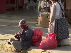 Woman tying sacks to man's back to carry, Cochabamba, Bolivia Stock Footage