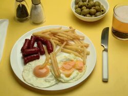 CU Hand eating Chorizo, eggs & chips with drink Stock Footage