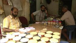 A vendor reviews paperwork near spices at a table. Stock Footage