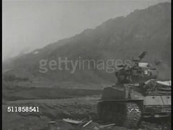 1950: KOREAN CONFLICT (WAR): Australian 'Diggers' (soldiers) walking across field. VS Tank firing in valley. MS Young adult US soldiers. VS US soldiers firing artillery.  The Cold War, troops, UN Forces. Instructional Video