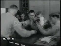 1942: U.S. MARINE RECRUITS: UNIFORMS: MS Newly enlisted men getting clothes from counter. WS Men changing into uniforms, putting on pants, being weighed. EXT WS Uniformed recruits walking out, lined up BG. USA Instructional Video