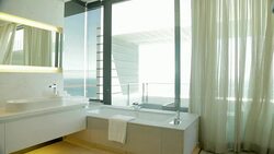 Wind blowing curtain in luxury master bathroom overlooking ocean Stock Footage