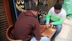 Two men playing backgammon board game at Cairo street market Stock Footage