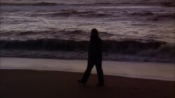 A silhouetted woman walks on a beach on the island of Sylt, Germany. Stock Footage