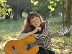 Young woman posing, flirting, holding guitar in park, summer. Stock Footage