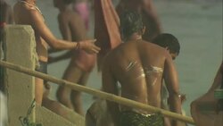 Men wearing swim trunks lather themselves in a river. Stock Footage