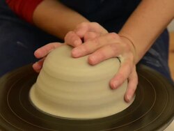 CU Shot of female potter shapes pot from lump of clay on potterwheel at pottery / Landshut, Bavaria, Germany Stock Footage