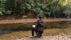 Wildlife Photographer taking picture of bird in the rainforest jungle Stock Footage