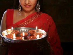 CU TU Young woman bringing up plate of oil lamps to her face and smiling / Singapore Stock Footage