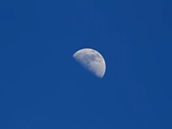MS Shot of Quarter Moon and clouds moving across blues sky / Polihe Beach, Kauai Hawaii, United States Stock Footage