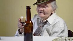 Elderly woman drinking beer. Stock Footage