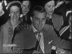 1952: NEW YORK CITY: TIMES SQUARE: NIGHT: VOX POPS: Unidentified host w/ mic & people asking questions for Eisenhower: He & MacArthur said military man shouldn't be president, why mind change? McCarthyism, will the witch hunts continue? WS Crowd, SOFT Instructional Video