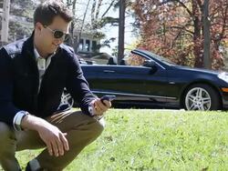 MS Young man using his cellular device outside in park next to his modern convertible car on sunny day / Minneapolis, Minnesota, United States Stock Footage