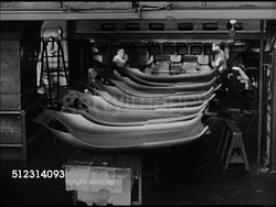 1947: CLEVELAND INDUSTRY: OHIO: VS Automobile body part being moved by workers off assembly line, machine pressing steel sheet into top of car frame, being placed on assembly line. EXT WS Trucks pulling newly made truck-tractors. Car factory, automotive Instructional Video