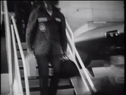 B/W 1960s tilt up soldiers carrying luggage walking down stairs from C-135 cargo plane / Vietnam War Stock Footage