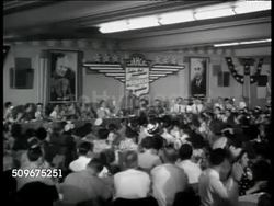 1943: COMPANY MEETING: Carter Hotel marquee. INT Hotel banquet room staff meeting, Bill Jack speaking to workers saying they continue to beat production records, if government thinks that's record, wait until year end. Workers applauding. Instructional Video