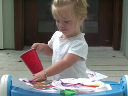 Little girl pours water on her painting Stock Footage