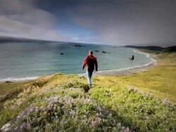 WS SLO MO POV View of young man walking on trail by ocean / Cape Blanco State Park, Oregon, United States Stock Footage