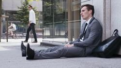 Desperate businessman sitting on the street Stock Footage