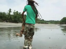 father and son with dreadlocks playing on the beach Stock Footage
