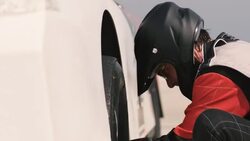Stock car pit-crewman tightens new race-car tire lug-nuts Stock Footage
