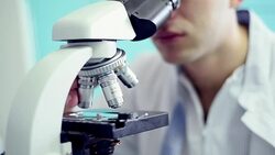 Young scientist looking through microscope in the lab Stock Footage