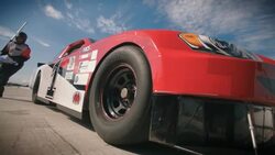 Stock car driver pulls into pit-road, pit-crew leaps into action, jacks race-car and removes lug-nuts Stock Footage
