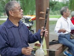 MS Old man playing chinese traditional musical instruments(Erhu and the Banhu) in park /Xi'an, Shaanxi, China Stock Footage