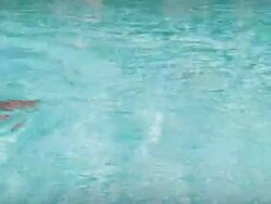 Swimmer in a Frog Costume Swim Across the Screen Stock Footage