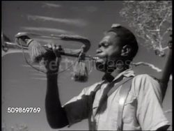 1941: FRENCH TERRITORIES: NEW CALEDONIA: Indigenous Melanesian men in Free French uniforms walking roadway. MS Indigenous Melanesian bugler, WS Men training running down, up hillside paths. Indigenous people's of Oceania, not 'Kanaks', Colonial Rule. Instructional Video