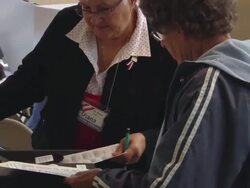 MS, ZO, Supervisor helping woman inserting voting ballot into electronic voting machine, St. Marys, Ohio, USA, DEFOCUS Stock Footage