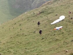 MS SLO MO Shot of Two paragliders on side of hill adjusting there parachutes Stock Footage