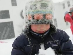 CU ZI ZO Boy smiling and eating snow during snow storm / Yarmouth, Maine, USA Stock Footage