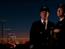 M/S two airline pilots watch as airplane passes overhead on approach to landing, night: Boeing-737 Stock Footage