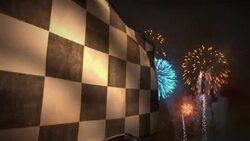 Fireworks light up the night sky as a  black and white checkered racing flag blows in the breeze. Stock Footage