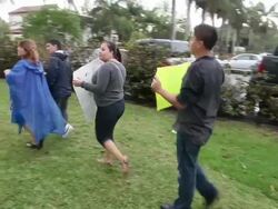 Long shot and pan to left of protesters marching with banners, mid circular tracking shot of protester encouraging other protester to chant louder Immigration Activists Protest Outside Of Marco Rubio Fundraiser at Biltmore Hotel on April 05, 2013 in Miami, Stock Footage