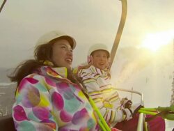 Two young girls riding chair lift at ski hill Stock Footage