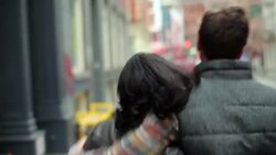 Happy New York couple walk down sidewalk in Soho, girl rests head on boyfriend's shoulder Stock Footage