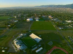 Low altitude aerial flight over campus of Montana State University with town of Bozeman in BG Stock Footage